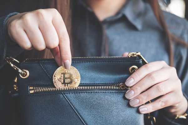 femme tenant une portefeuille de crypto