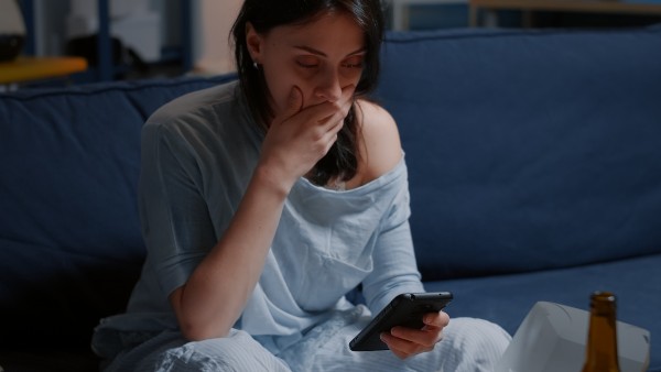 une femme choquée devant son téléphone 