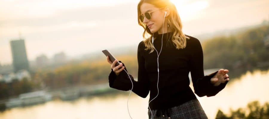 une femme utilisant son smartphone au soleil