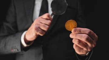 Homme surveillant crypto à la loupe