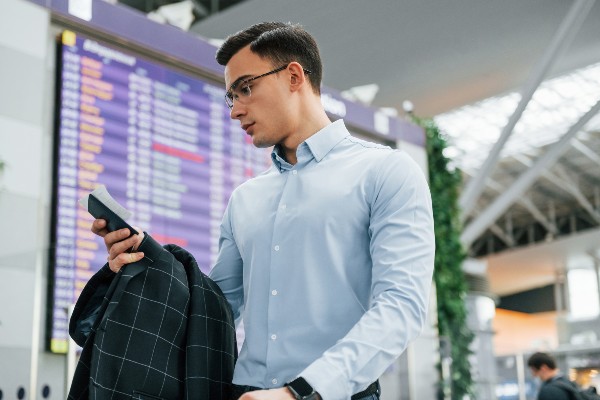 Un homme utilisant son téléphone à l'aéroport