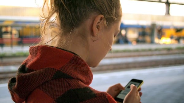 une femme regardant son téléphone dans la rue 